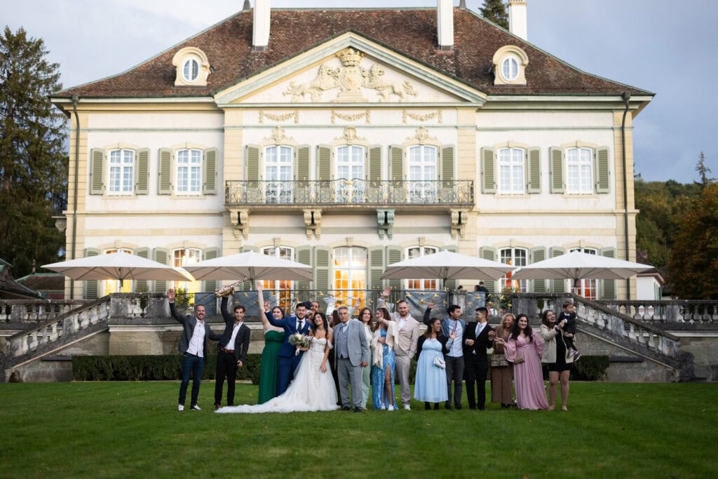 Foto di gruppo nel giardino durante il matrimonio a Villa Wenkenhof a Basilea