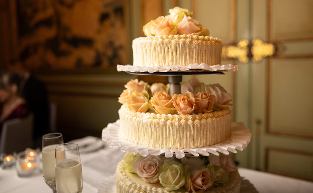 Emotional cake-cutting moment with bride and groom smiling at Villa Wenkenhof wedding in Switzerland.