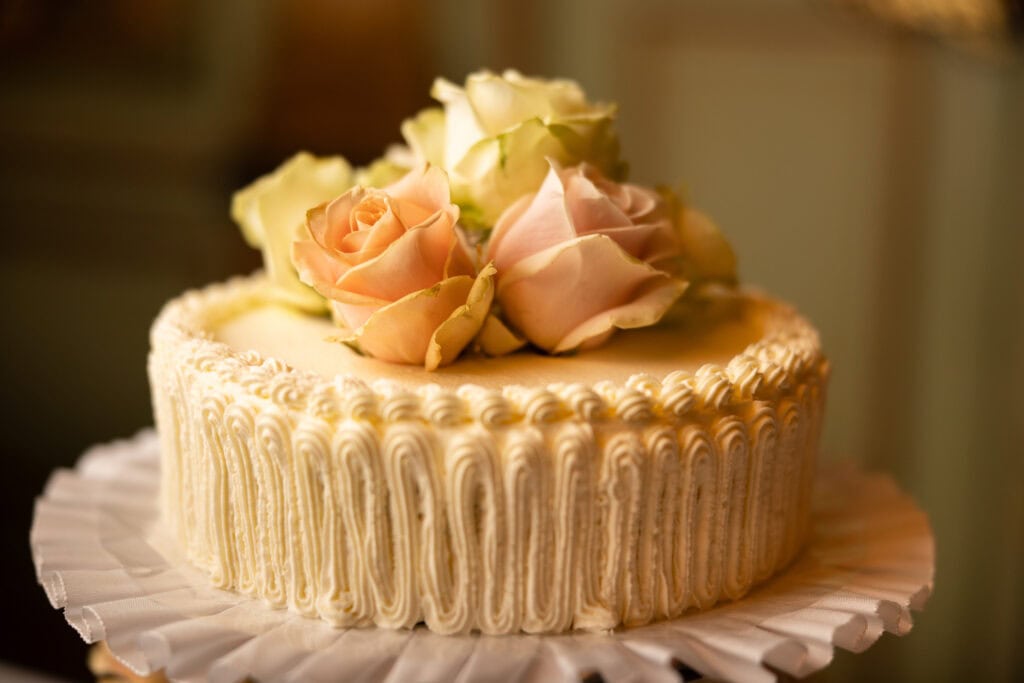 Emotional cake-cutting moment with bride and groom smiling at Villa Wenkenhof wedding in Switzerland.