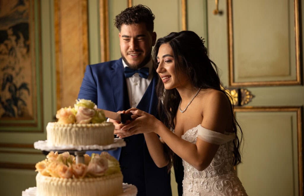 Emotional cake-cutting moment with bride and groom smiling at Villa Wenkenhof wedding in Switzerland.