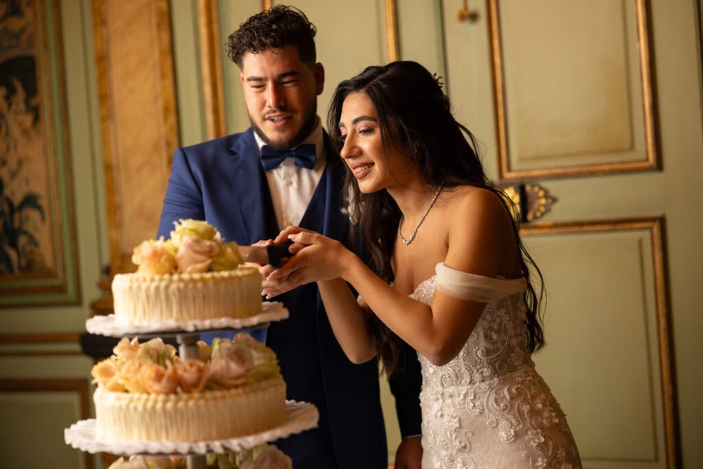 Emotional cake-cutting moment with bride and groom smiling at Villa Wenkenhof wedding in Switzerland.