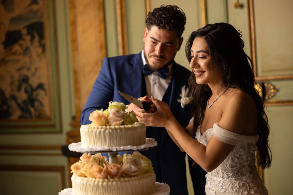 Emotional cake-cutting moment with bride and groom smiling at Villa Wenkenhof wedding in Switzerland.