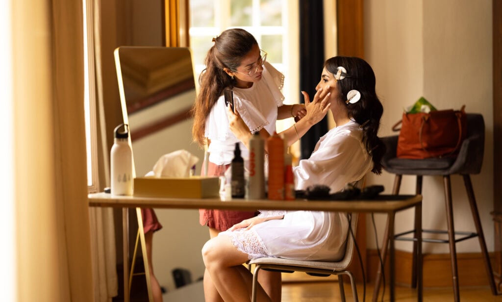 Bridal makeup artist applying makeup, wedding preparation, elegant bride getting ready.