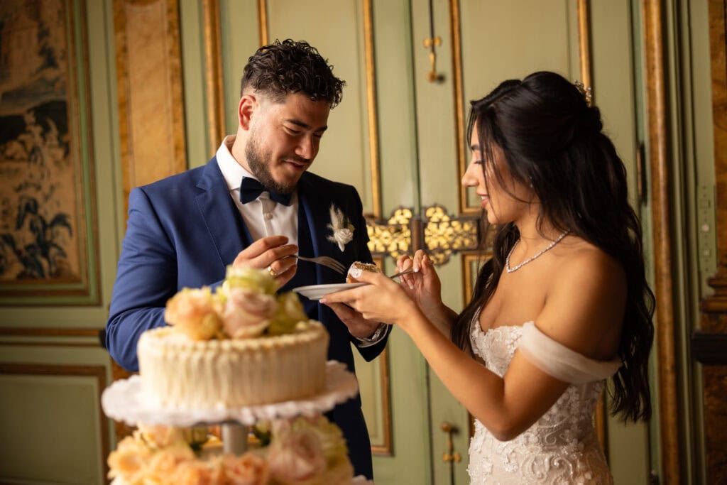 Emotional cake-cutting moment with bride and groom smiling at Villa Wenkenhof wedding in Switzerland.