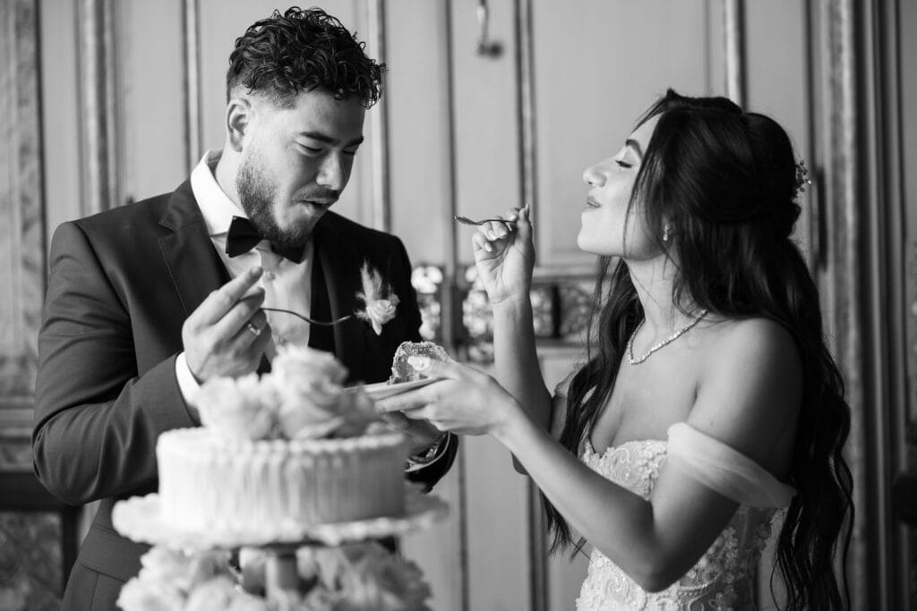 Emotional cake-cutting moment with bride and groom smiling at Villa Wenkenhof wedding in Switzerland.