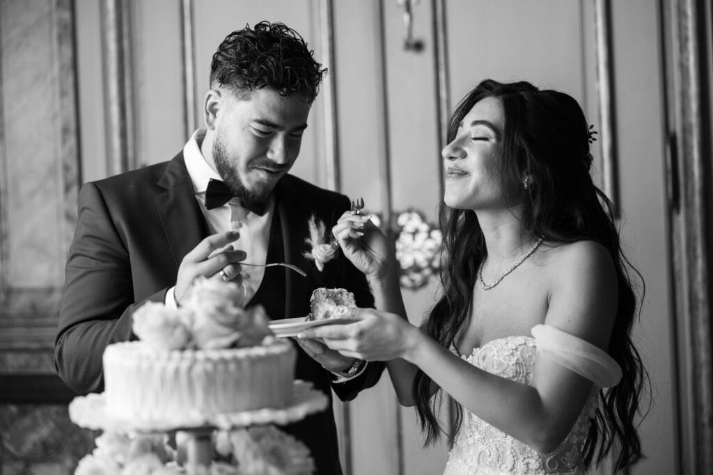 Emotional cake-cutting moment with bride and groom smiling at Villa Wenkenhof wedding in Switzerland.