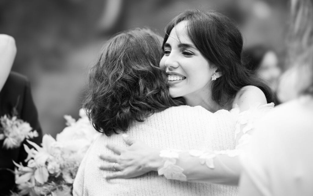 Wedding ceremony in the garden. Schloss Hünigen. Emotional and colorful wedding ceremony. Emotional hugs with family and friends after the wedding ceremony