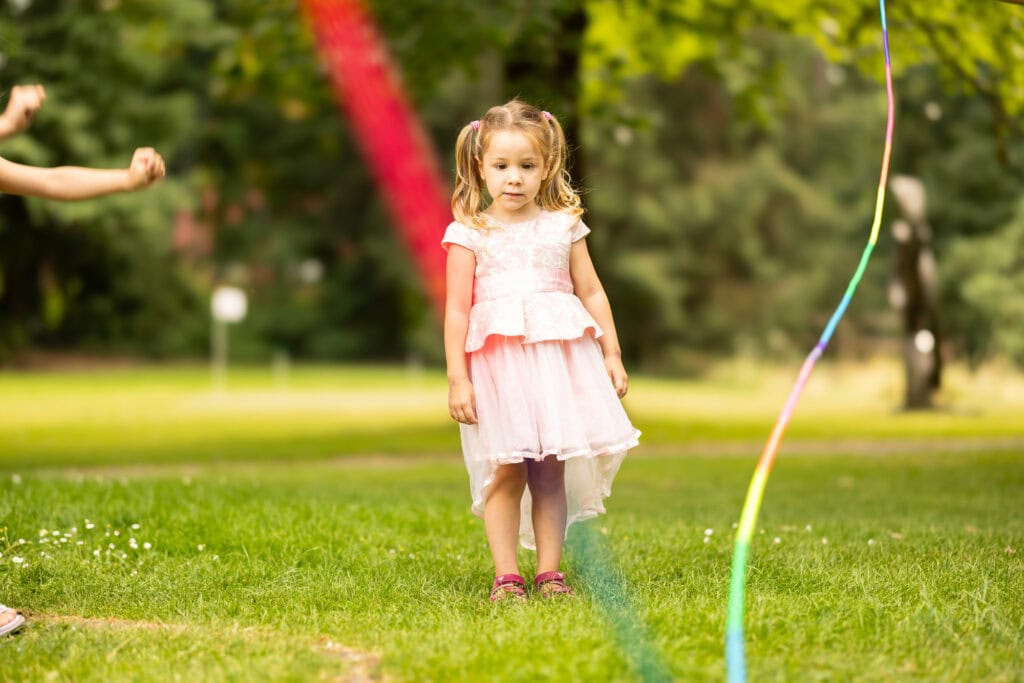 Wedding ceremony in the garden. Schloss Hünigen. Emotional and colorful wedding ceremony. Emotional hugs with family and friends after the wedding ceremony. Kids playing