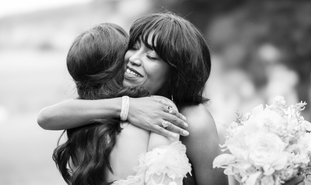 Wedding ceremony in the garden. Schloss Hünigen. Emotional and colorful wedding ceremony. Emotional hugs with family and friends after the wedding ceremony