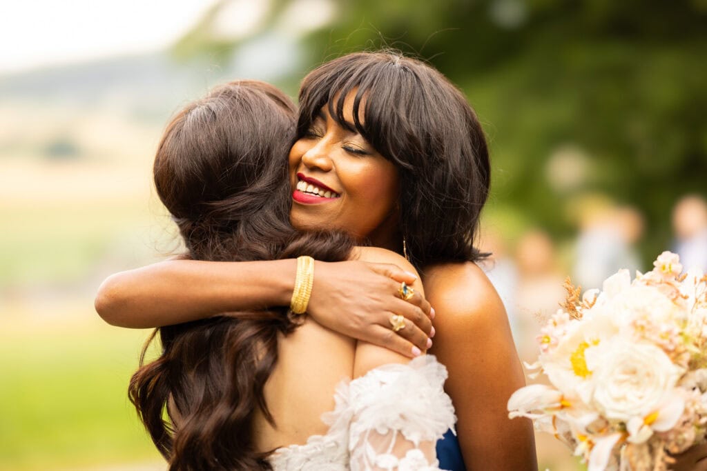 Wedding ceremony in the garden. Schloss Hünigen. Emotional and colorful wedding ceremony. Emotional hugs with family and friends after the wedding ceremony