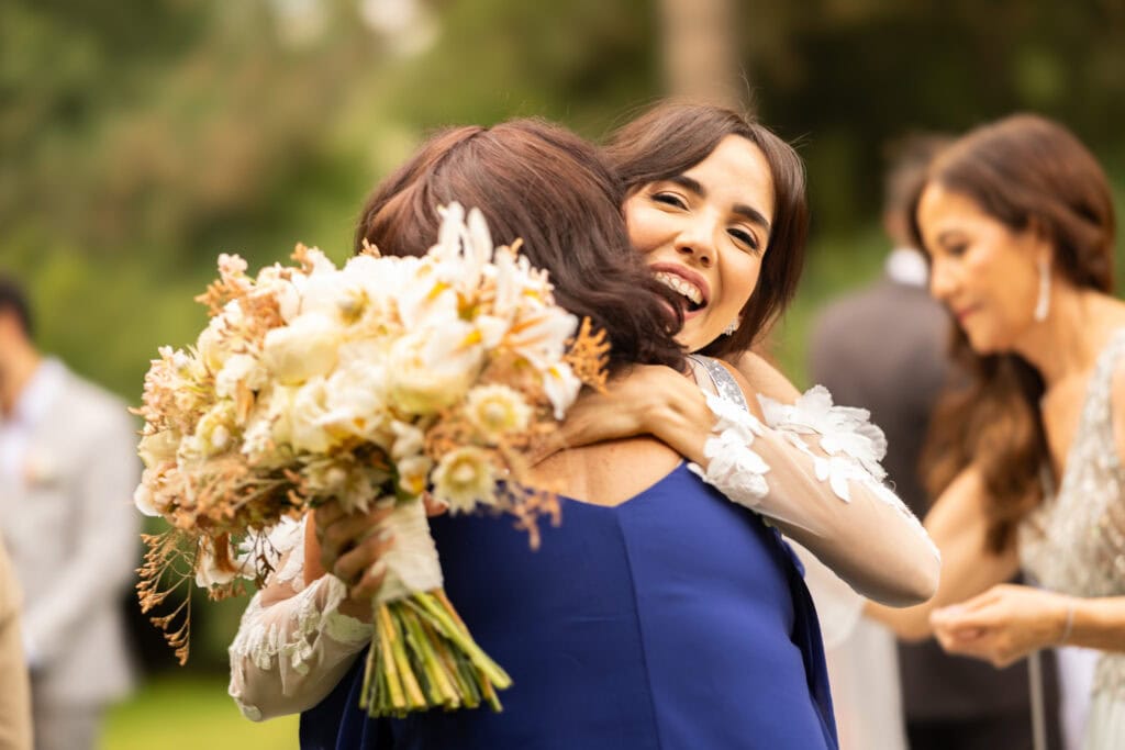 Wedding ceremony in the garden. Schloss Hünigen. Emotional and colorful wedding ceremony. Emotional hugs with family and friends after the wedding ceremony