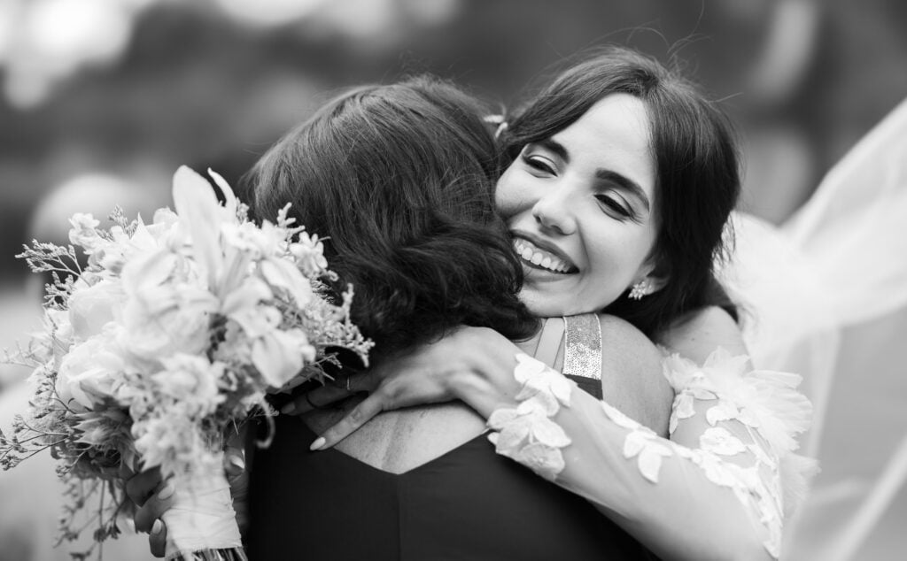 Wedding ceremony in the garden. Schloss Hünigen. Emotional and colorful wedding ceremony. Emotional hugs with family and friends after the wedding ceremony