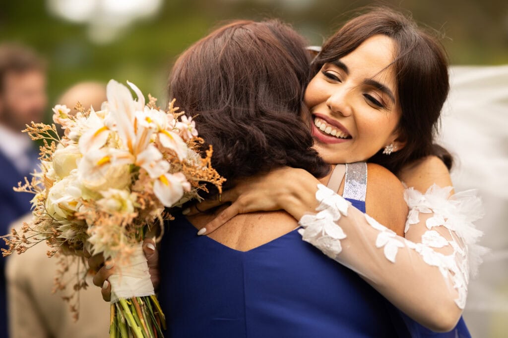Wedding ceremony in the garden. Schloss Hünigen. Emotional and colorful wedding ceremony. Emotional hugs with family and friends after the wedding ceremony
