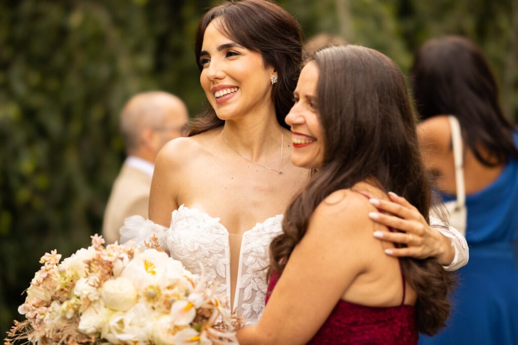 Wedding ceremony in the garden. Schloss Hünigen. Emotional and colorful wedding ceremony. Emotional hugs with family and friends after the wedding ceremony
