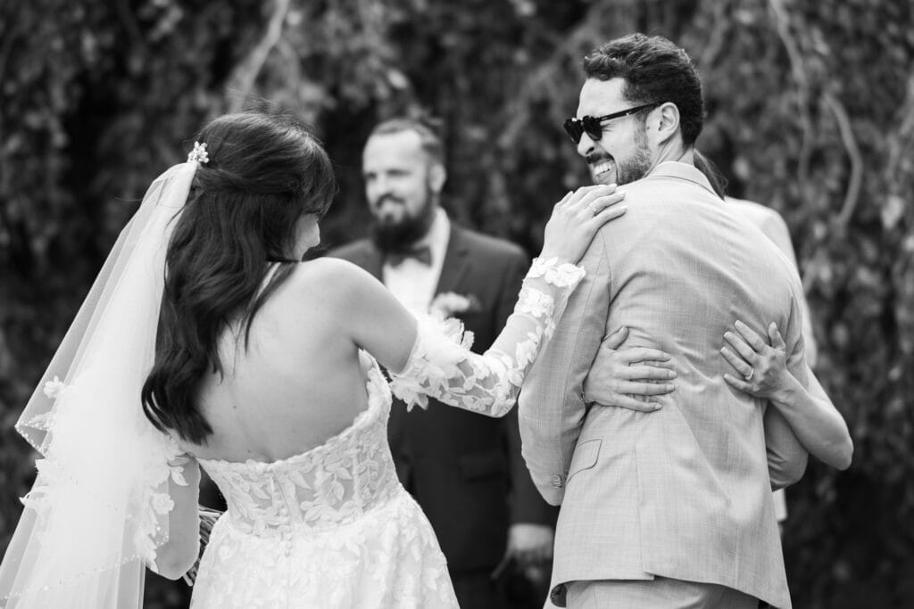 Wedding ceremony in the garden. Schloss Hünigen. Emotional and colorful wedding ceremony. Emotional hugs with family and friends after the wedding ceremony. Bride with her brother