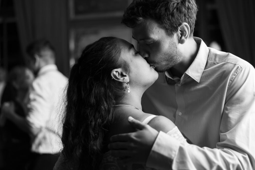 Guests kissing and celebrating during the wedding party at Villa Wenkenhof in Basel.