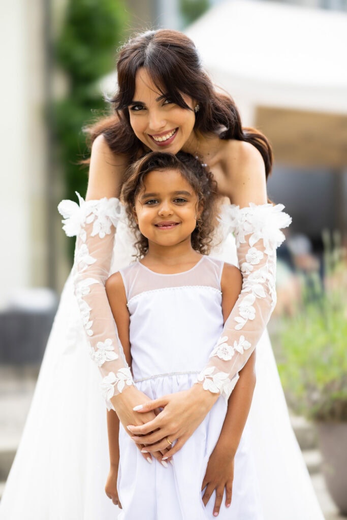 Wedding ceremony in the garden. Schloss Hünigen. Emotional and colorful wedding ceremony. Emotional hugs with family and friends after the wedding ceremony. Bride with a kid