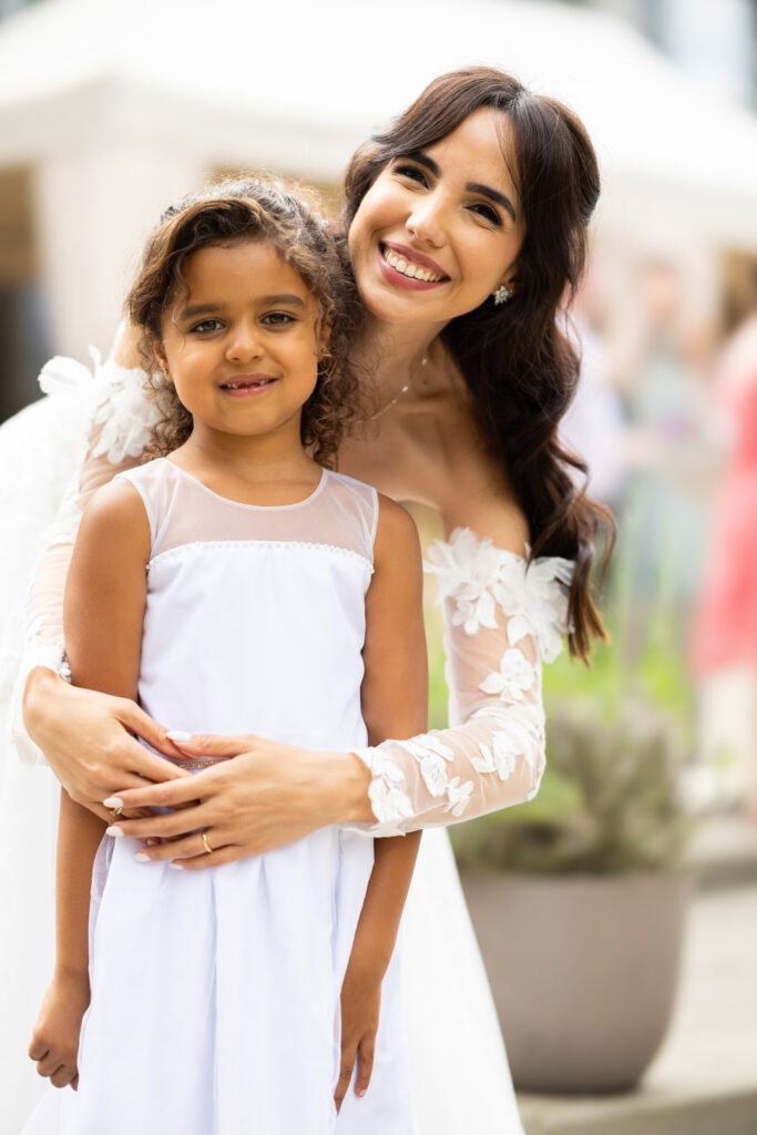 Wedding ceremony in the garden. Schloss Hünigen. Emotional and colorful wedding ceremony. Emotional hugs with family and friends after the wedding ceremony. Bride with kid