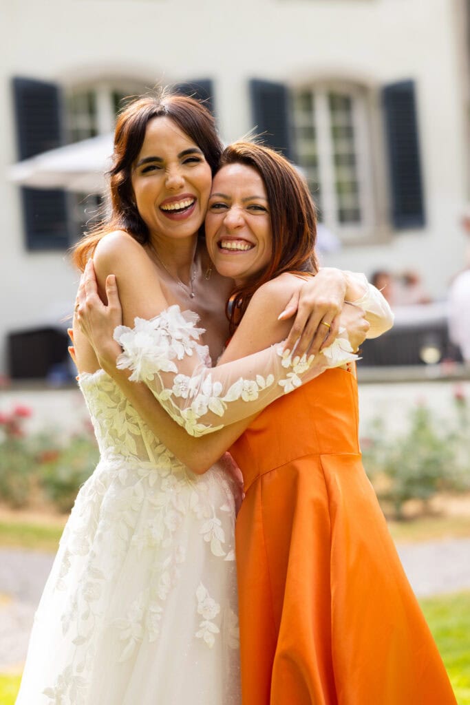 Wedding ceremony in the garden. Schloss Hünigen. Emotional and colorful wedding ceremony. Emotional hugs with family and friends after the wedding ceremony.