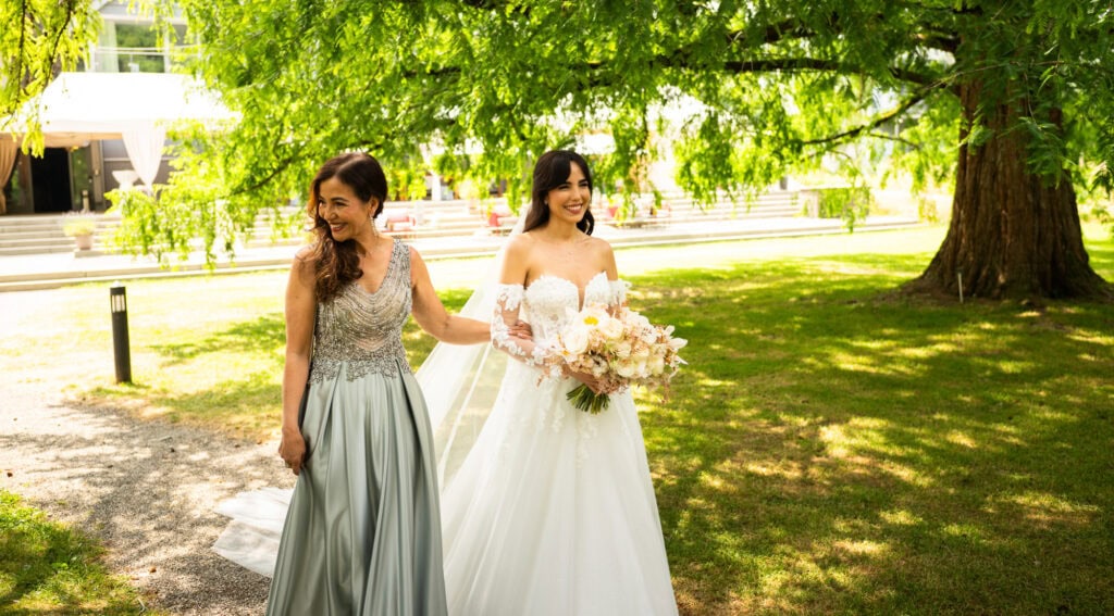 Wedding ceremony in the garden. Schloss Hünigen. Emotional and colorful wedding ceremony. Entry bride and her mum