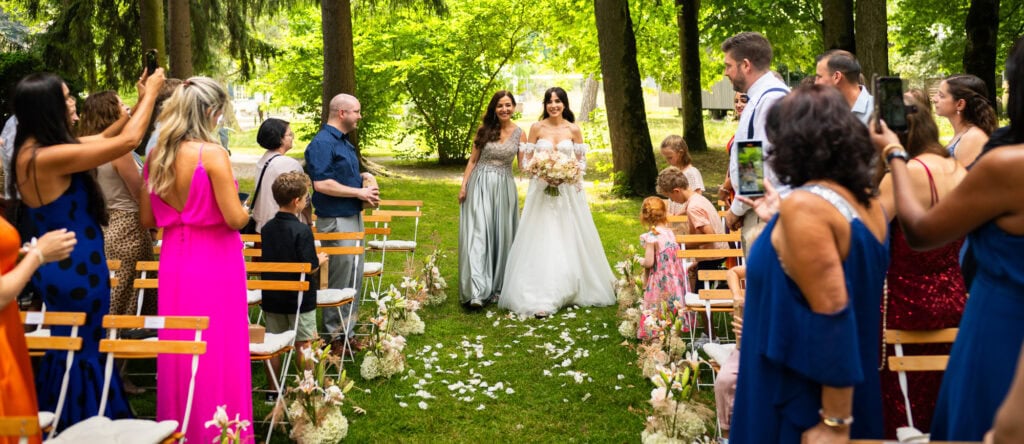 Wedding ceremony in the garden. Schloss Hünigen. Emotional and colorful wedding ceremony. Entry bride and her mum