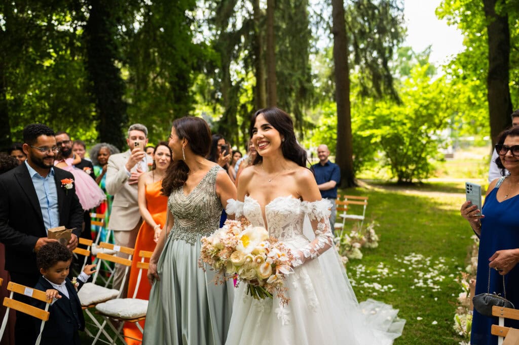 Wedding ceremony in the garden. Schloss Hünigen. Emotional and colorful wedding ceremony. Entry bride and her mum