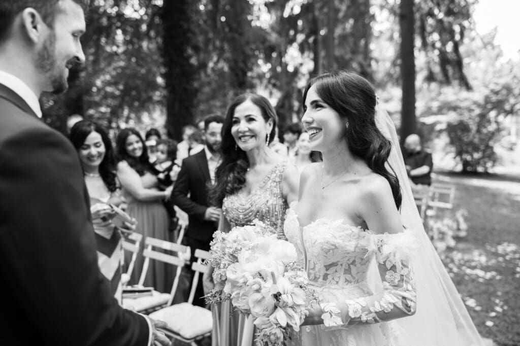 Wedding ceremony in the garden. Schloss Hünigen. Emotional and colorful wedding ceremony. Entry bride and her mum