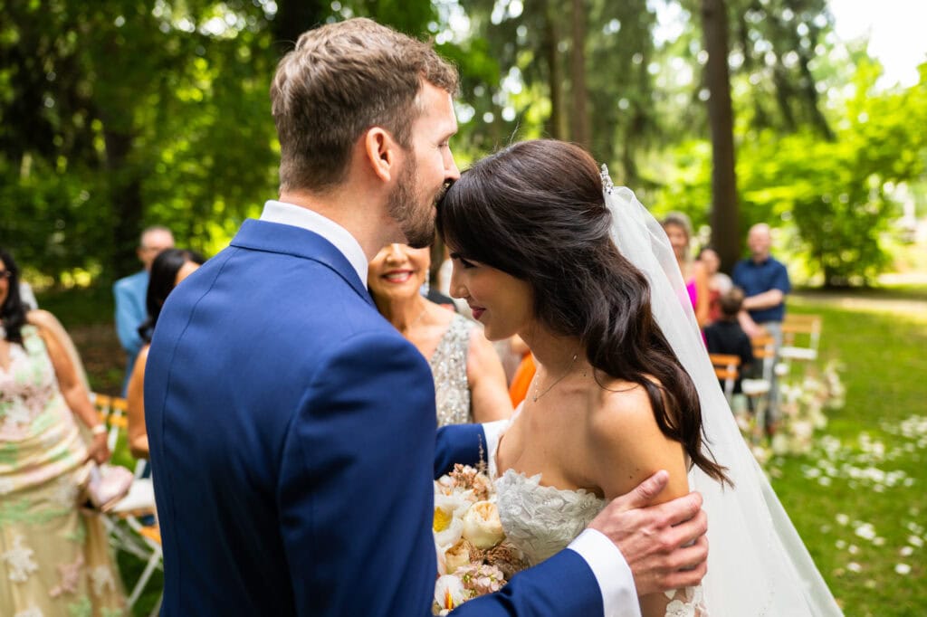 Wedding ceremony in the garden. Schloss Hünigen. Emotional and colorful wedding ceremony. Entry bride and her mum. Groom kissing bride