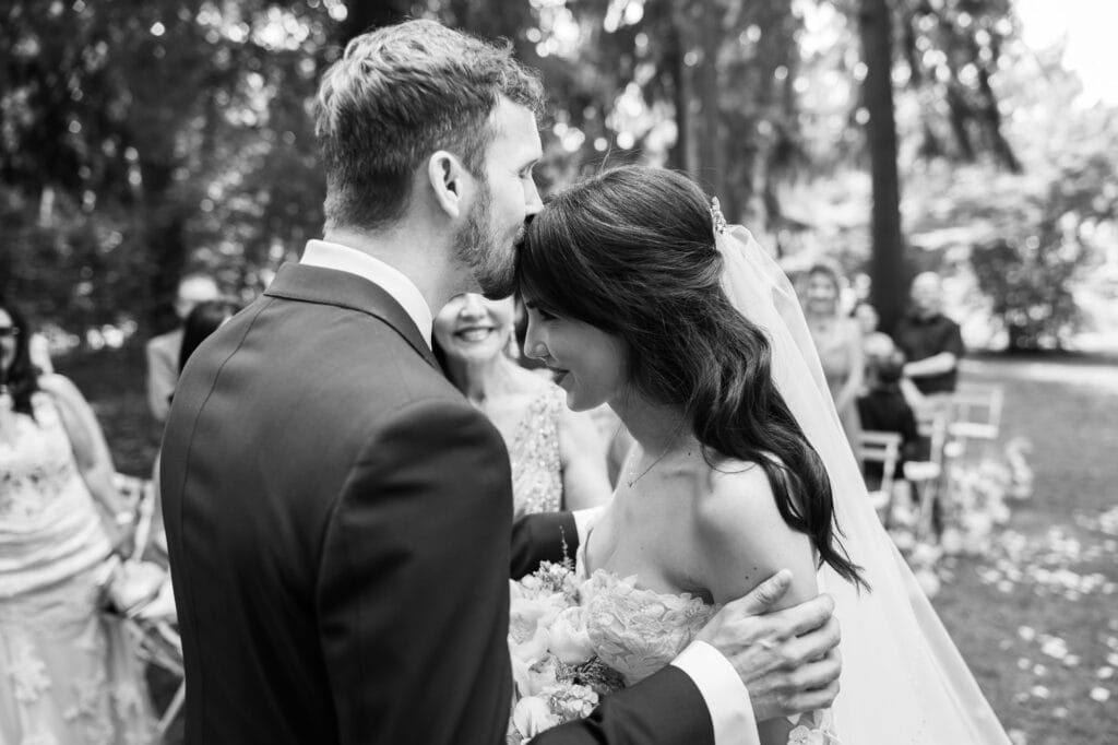 Wedding ceremony in the garden. Schloss Hünigen. Emotional and colorful wedding ceremony. Entry bride and her mum. Groom kissing bride