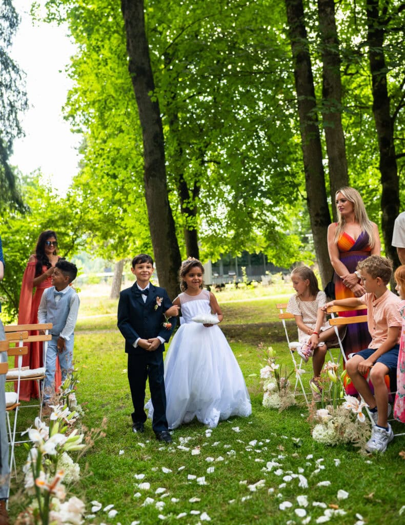 Wedding ceremony in the garden. Schloss Hünigen. Emotional and colorful wedding ceremony. Kids bringing rings