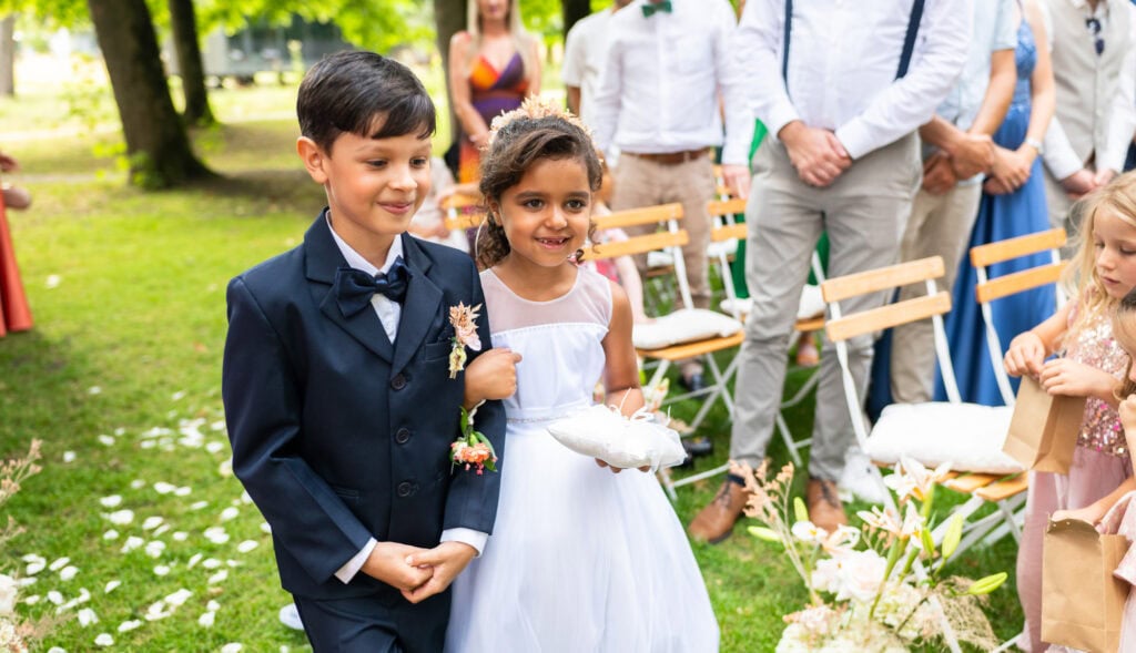 Wedding ceremony in the garden. Schloss Hünigen. Emotional and colorful wedding ceremony. Kids bringing rings