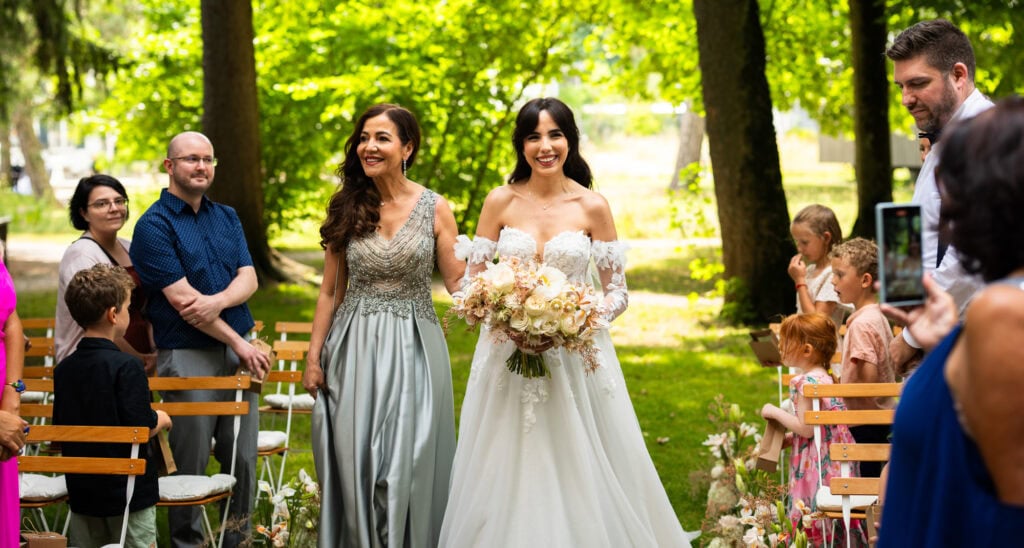 Wedding ceremony in the garden. Schloss Hünigen. Emotional and colorful wedding ceremony. Entry bride and her mum