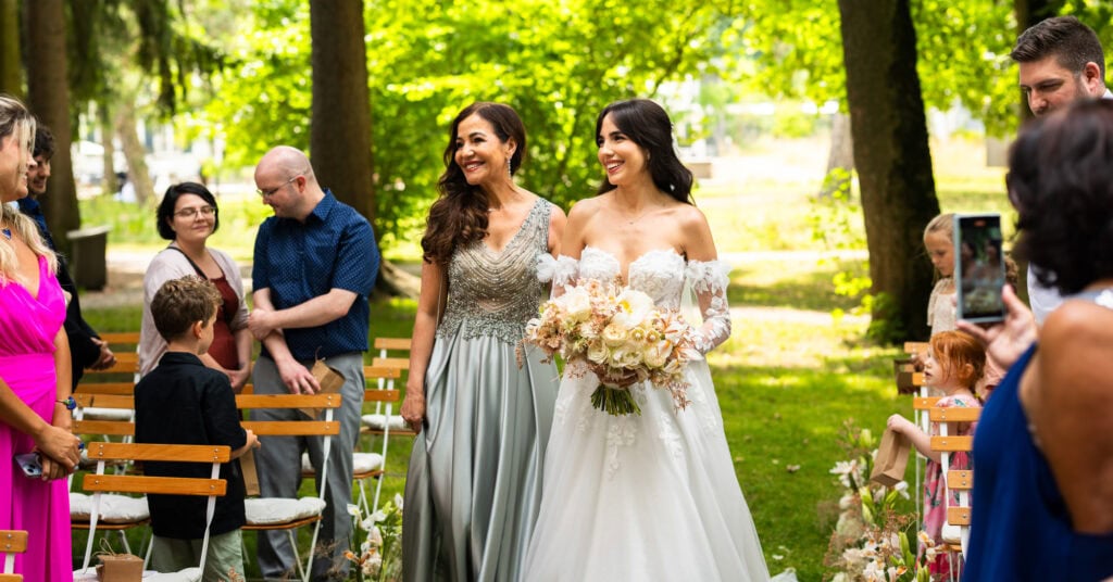 Wedding ceremony in the garden. Schloss Hünigen. Emotional and colorful wedding ceremony. Entry bride and her mum