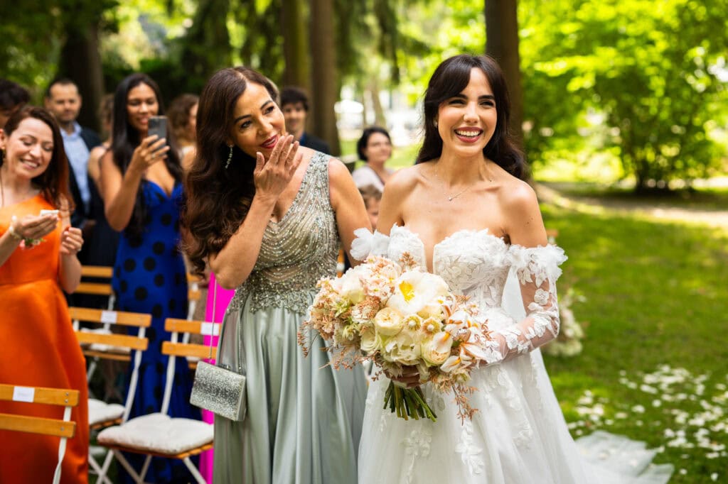 Wedding ceremony in the garden. Schloss Hünigen. Emotional and colorful wedding ceremony. Entry bride and her mum