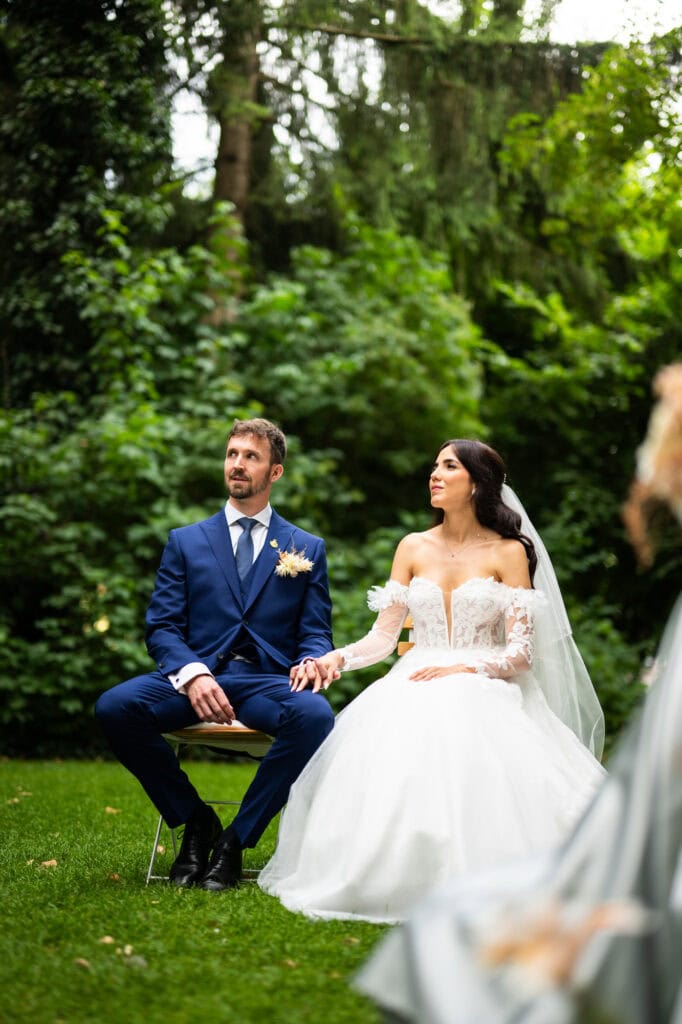 Wedding ceremony in the garden. Schloss Hünigen. Emotional and colorful wedding ceremony. Bride and groom