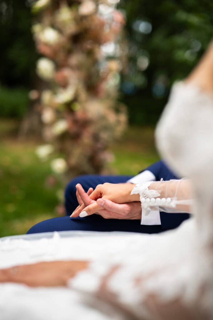 Wedding ceremony in the garden. Schloss Hünigen. Emotional and colorful wedding ceremony. Hands