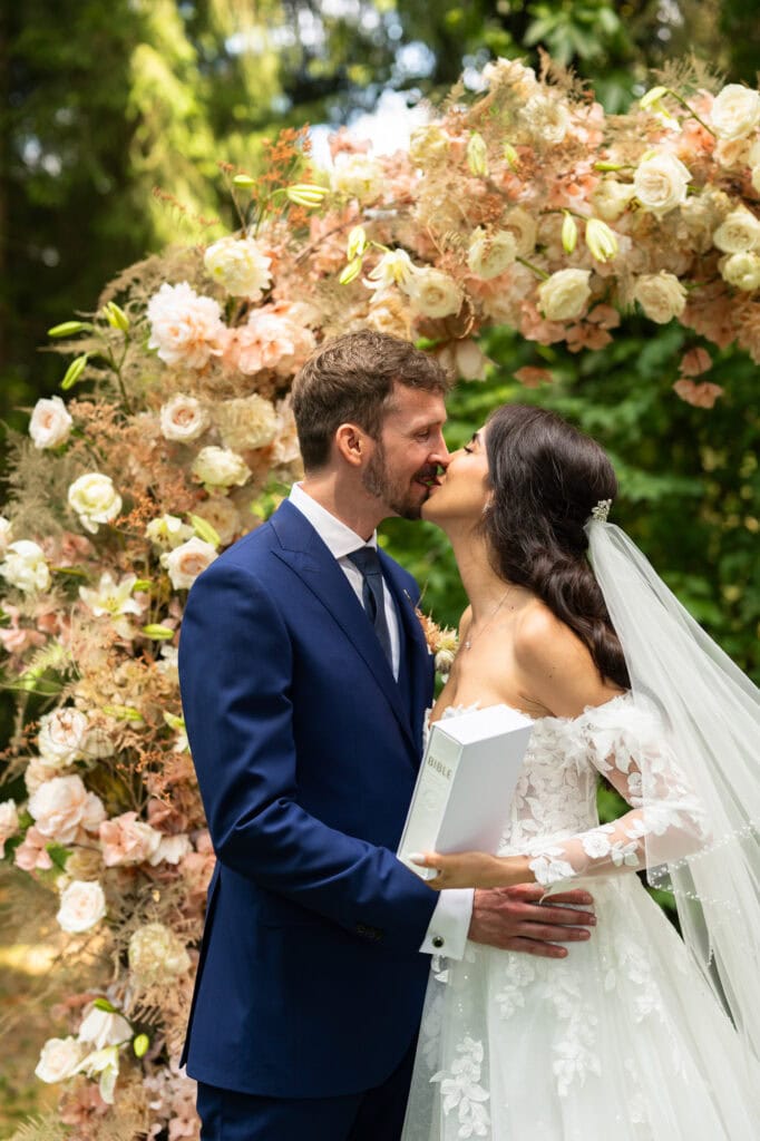 Wedding ceremony in the garden. Schloss Hünigen. Emotional and colorful wedding ceremony. Kiss
