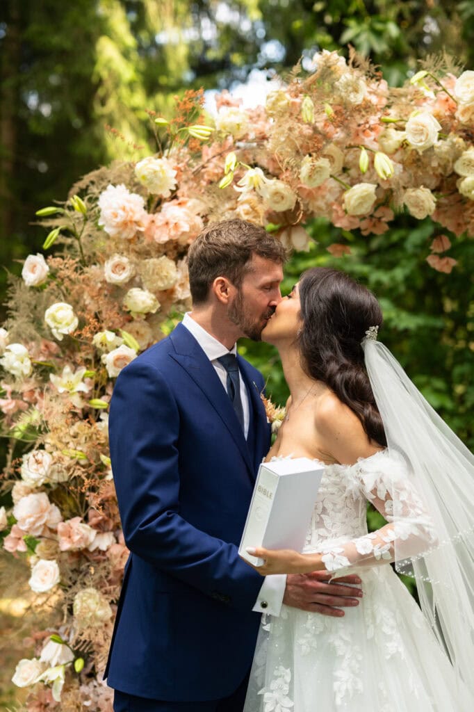 Wedding ceremony in the garden. Schloss Hünigen. Emotional and colorful wedding ceremony. Kiss
