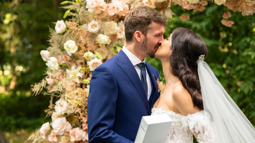 Wedding ceremony in the garden. Schloss Hünigen. Emotional and colorful wedding ceremony. Kiss