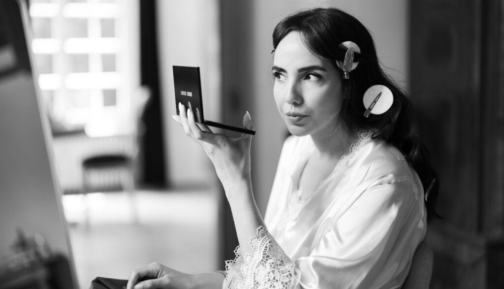 Bridal makeup artist applying makeup, wedding preparation, elegant bride getting ready.