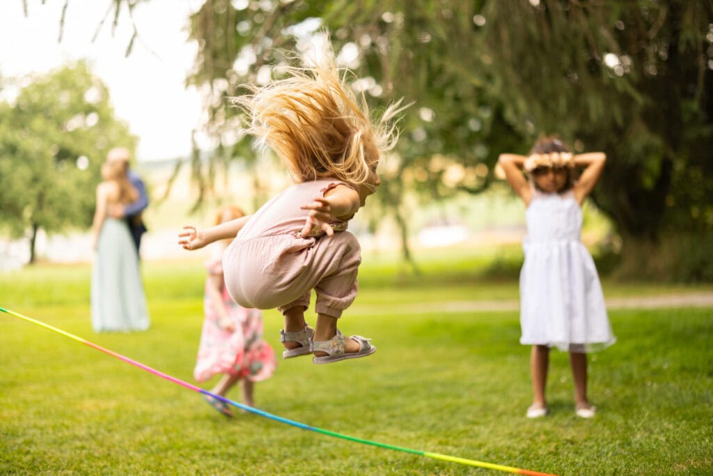 Wedding ceremony in the garden. Schloss Hünigen. Emotional and colorful wedding ceremony. Emotional hugs with family and friends after the wedding ceremony. Kids playing