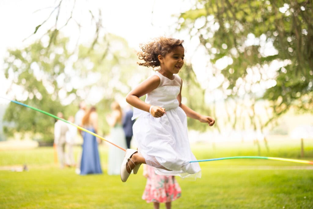 Wedding ceremony in the garden. Schloss Hünigen. Emotional and colorful wedding ceremony. Emotional hugs with family and friends after the wedding ceremony. Kids playing