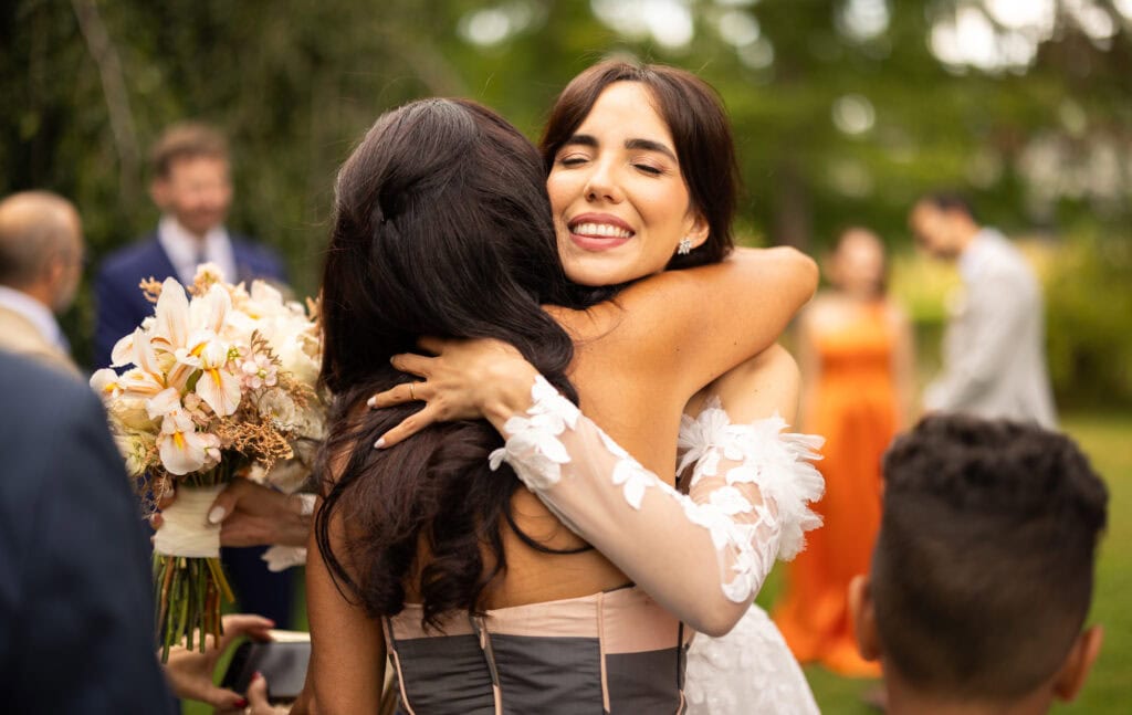 Wedding ceremony in the garden. Schloss Hünigen. Emotional and colorful wedding ceremony. Emotional hugs with family and friends after the wedding ceremony.