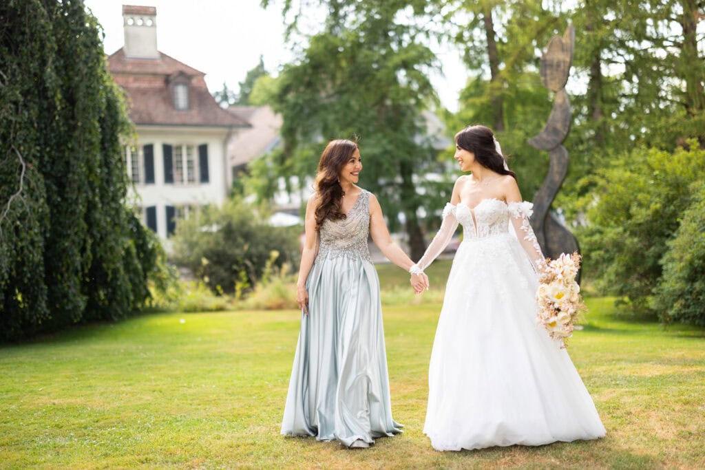 Wedding ceremony in the garden. Schloss Hünigen. Emotional and colorful wedding ceremony. Emotional hugs with family and friends after the wedding ceremony. Bride with her mum