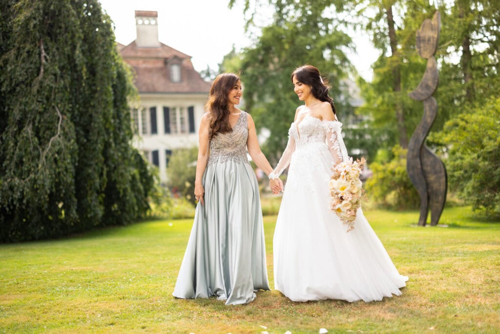 Wedding ceremony in the garden. Schloss Hünigen. Emotional and colorful wedding ceremony. Emotional hugs with family and friends after the wedding ceremony. Bride with her mum