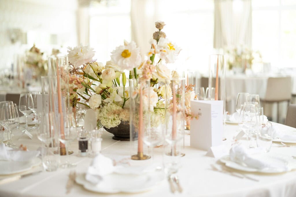 Table decoration with elegant floral arrangements by Karin Mani during a wedding at Schloss Hünigen in Bern