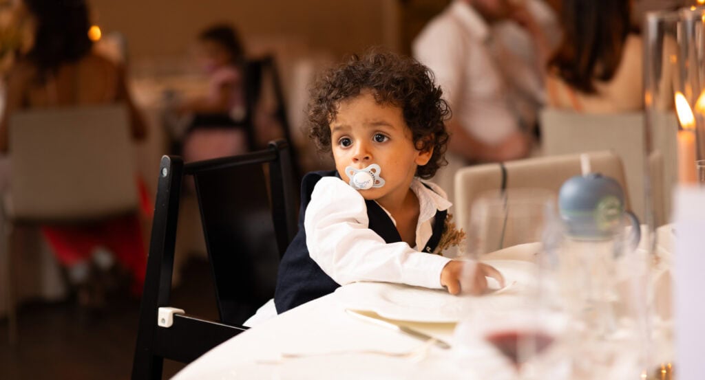 Children sitting at the dinner table during the wedding reception at Schloss Hünigen in Bern